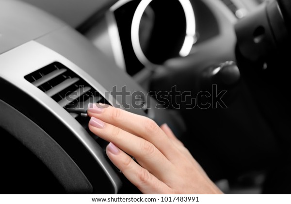 Woman adjusting
air conditioner in car,
closeup