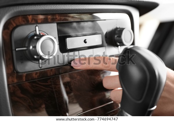 Woman adjusting
air conditioner in car,
closeup