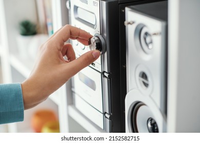 Woman adjusting a knob on the stereo system, home entertainment concept