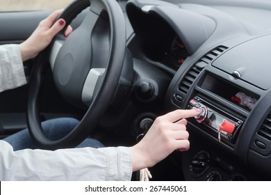 Woman Adjusting Radio Volume In The Car. 