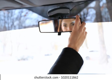 Woman Adjusting Rear View Mirror In Car