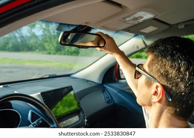 Woman adjusting rear view mirror inside car before driving - Powered by Shutterstock