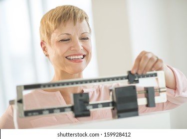 Woman Adjusting Sliding Weight Scale