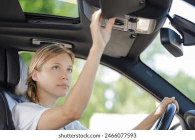 a woman adjusting sun visor - Powered by Shutterstock