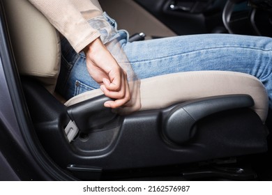 The woman adjusts the driver's seat to the proper position while driving, adjusting the driving position to be comfortable and safe.