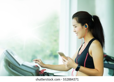 woman adjusts the treadmill at the beginning of training, do fitness in the sport club