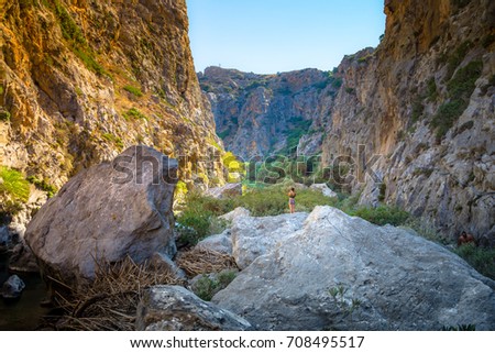 Woman admires the view of Kourtaliotis river and canyon near Preveli beach at Libyan sea, river and palm forest, southern Crete, Greece