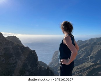 Woman admiring scenic mountain view on a sunny day from a peak - Powered by Shutterstock