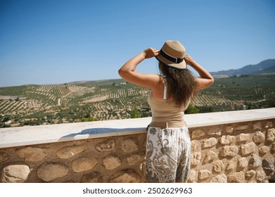 Woman admiring scenic valley view from stone terrace on a sunny day - Powered by Shutterstock