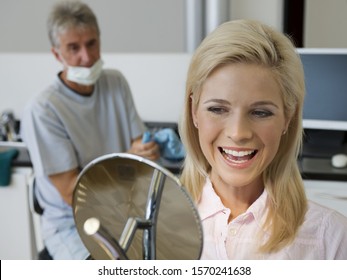 Woman admiring smile in dentist's office - Powered by Shutterstock