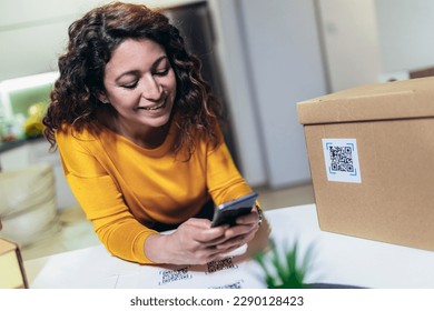 Woman affixing QR codes onto storage boxes. Concept organization, efficiency, or technology in storage management.
