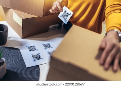 Woman affixing QR codes onto storage boxes. Concept organization, efficiency, or technology in storage management. - Powered by Shutterstock