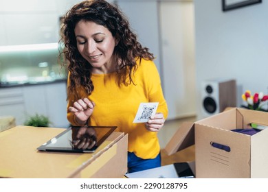 Woman affixing QR codes onto storage boxes. Concept organization, efficiency, or technology in storage management.
