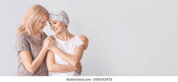 Woman after chemotherapy and her mother on light background with space for text - Powered by Shutterstock