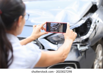 Frauenagenten fotografieren Schäden am Auto nach einem Unfall durch Smartphone