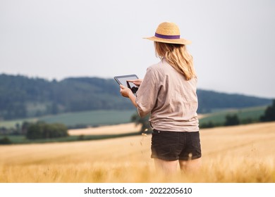 Woman agronomist using digital tablet and modern technology in agricultural field. Female farmer control quality of barley crop before harvesting - Powered by Shutterstock