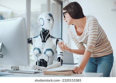Woman and AI robot working together in the office, automation and technology concept - Shutterstock ID 2320153385