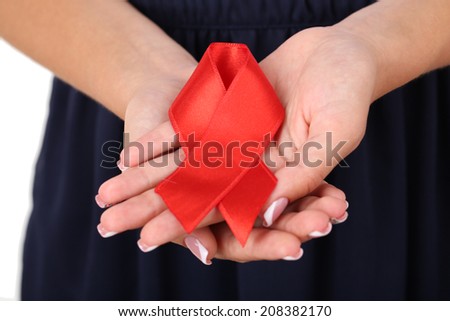 Woman with aids awareness red ribbon in hands, close-up