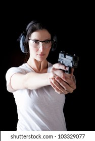 Woman aiming a gun with protective gear