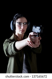 Woman aiming a gun with protective gear