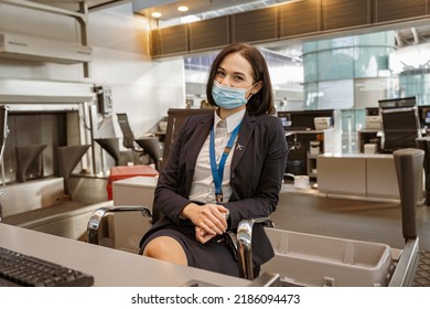 Woman Airline Employee Wearing Face Mask While Working At Airline Check In Counter In Airport