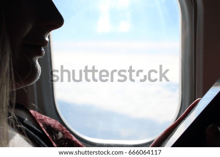 woman in a airplane is looking on the phone