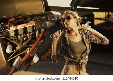 Woman Airplane Mechanic. Airplane On The Background