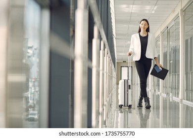 Woman at the airport. Girl with suitcase. Lady in a white jacket.