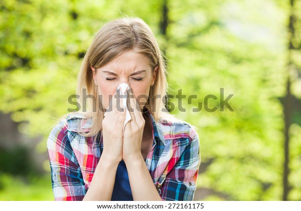 Woman with with\
allergy symptom blowing\
nose