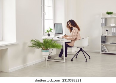 Woman analyst working with spreadsheet business data in office. Focused female financial manager sitting at PC screen, doing research, analysing data reports, working with business documents - Powered by Shutterstock