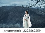 A woman in ancient Hanfu is standing under a pear tree