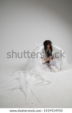 woman with angel wings in studio with white backgound