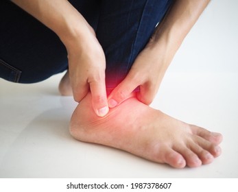 Woman With Ankle Pain Holding Her Aching Ankle.