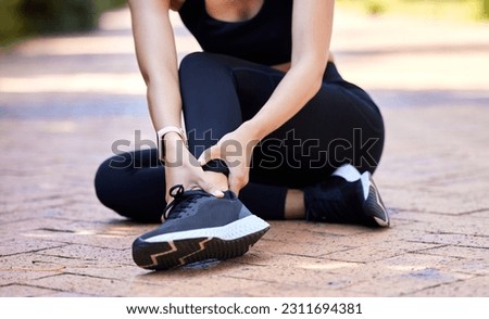 Woman with ankle pain, running injury and fitness with joint fracture, muscle inflammation and health problem. Female athlete injured on run outdoor, hands holding sore foot and healthcare emergency