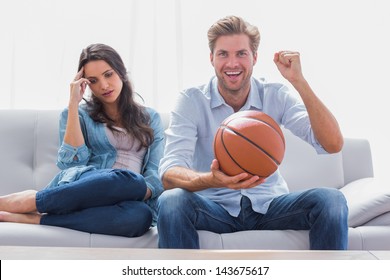 Woman Annoyed By Her Partner Watching Basketball Game In The Living Room