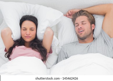 Frau ärgert über das Schnarchen ihres Partners in ihrem Bett