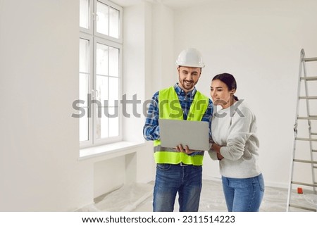 Woman apartment owner discussing home design plan with foreman. Professional builder showing project of renovation to young woman using laptop computer. Building and home renovation