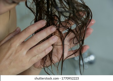 Woman Applaying Conditioner On Her Wet Tangled Hair In The Shower Cabin.