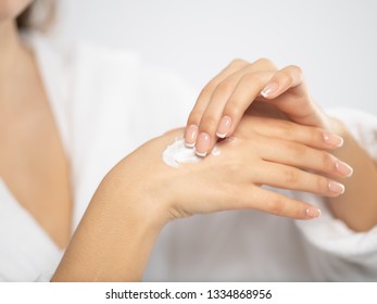 Woman applies a cosmetic moisturizer on her hands. Beautiful female hands. Woman gets manicure procedure in a spa salon. Hand care. Woman cares for the hands. Beauty treatment with skin of hand.   - Shutterstock ID 1334868956