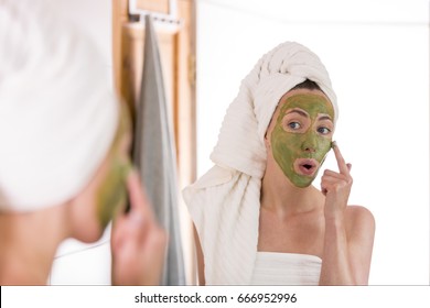 The Woman Applies Green Organic Face Mask In The Bathroom