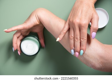 woman applies a jar of cleansing skin scrub to her hand,cosmetics daily rituals