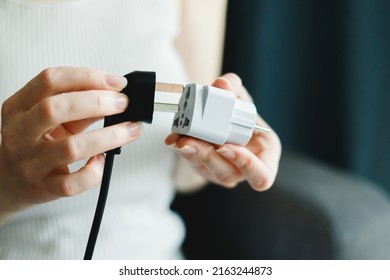 Woman applies universal travel adapter electrical plug converter power socket - Shutterstock ID 2163244873