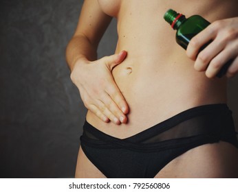 Woman apply body oil cream on abdomen