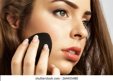 woman apply a sponge egg foundation