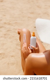 Woman Apply Sun Protection Cream On Her Smooth Tanned Legs.