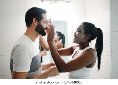 Woman Applying Beauty Mask And Skin Cleanser To Man