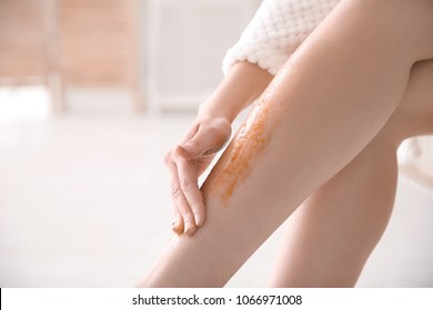 Woman Applying Body Scrub On Legs, Closeup