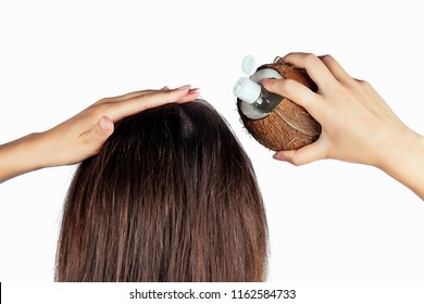 Woman Applying Coconut Oil Bottle And Cap To Hair In A Hand On White Isolate Back View