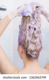 Woman Applying Coloring Shampoo On Her Hair. Female Having Purple Washing Product. Toning Blonde Color At Home.