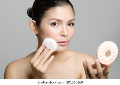 Woman Applying Cosmetic Powder Puff On Her Face